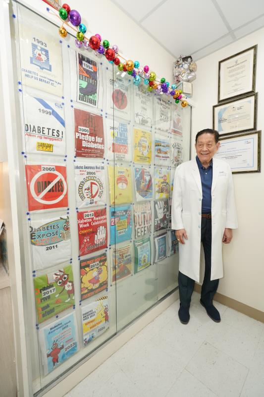 Dr Litonjua right next to the Diabetes Center’s display cabinet showing the organization’s event t-shirts